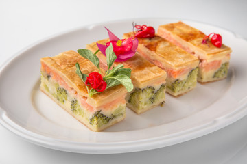 Quiche, casserole, delicious omelet from eggs, cheese, salmon, broccoli, spinach, pate. Banquet festive dishes. Gourmet restaurant menu. White background.