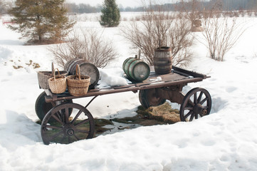 Fototapeta na wymiar horse carts in winter, snow. Barrels and baskets on wheels