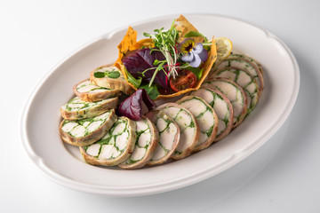 Roll of salmon and spinach. Delicate roll stuffed with fish, vegetables and herbs. Banquet festive dishes. Gourmet restaurant menu. White background.
