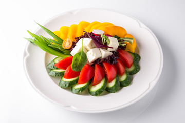 Snack from fresh vegetables and cheese. Tomatoes, cucumbers, peppers, onions. Banquet festive dishes. Gourmet restaurant menu. White background.