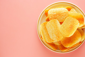 Crispy potato chips isolated over pink background. Top view. Copy space.