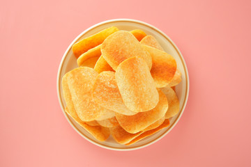 Crispy potato chips isolated over pink background. Top view. Copy space.