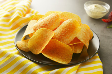 Crispy potato chips isolated over grey textured background. Top view. Copy space.