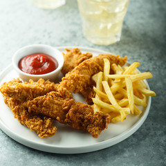 Homemade fish and chips on white plate