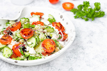 mediterranean couscous salad with fried cherry tomatoes, cucumber