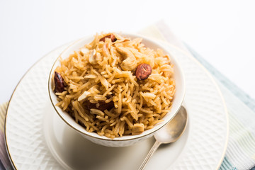 Traditional Jaggery Rice or Gur wale chawal in Hindi, served in a bowl with spoon. selective focus