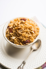 Traditional Jaggery Rice or Gur wale chawal in Hindi, served in a bowl with spoon. selective focus