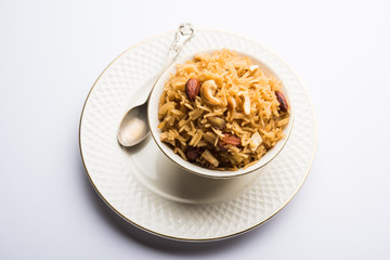 Traditional Jaggery Rice or Gur wale chawal in Hindi, served in a bowl with spoon. selective focus