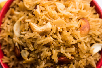 Traditional Jaggery Rice or Gur wale chawal in Hindi, served in a bowl with spoon. selective focus