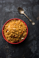 Traditional Jaggery Rice or Gur wale chawal in Hindi, served in a bowl with spoon. selective focus