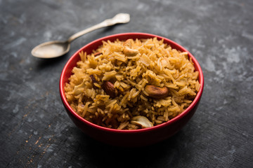 Traditional Jaggery Rice or Gur wale chawal in Hindi, served in a bowl with spoon. selective focus