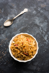 Traditional Jaggery Rice or Gur wale chawal in Hindi, served in a bowl with spoon. selective focus