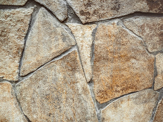 Imitation of a wild stone. Wall decorated with ocher stone tiles. The effect of the fortress. Close...