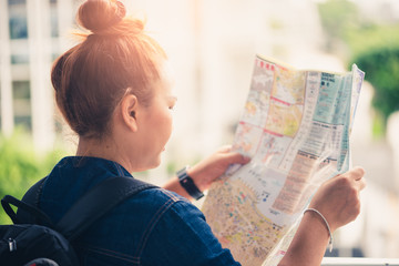 the abstract image of the woman tourist looking at the map for guiding to travel. the concept of travel, tourist, lifestyle, woman and adventure.
