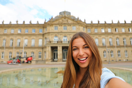 Self portrait of smiling young woman in front of Neues Schloss (New Palace) of Stuttgart, Germany
