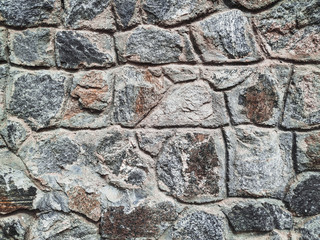 Old stone of wall texture. Lots of granite cobblestones. Close up, copy space.