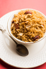 Traditional Jaggery Rice or Gur wale chawal in Hindi, served in a bowl with spoon. selective focus