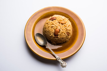 Traditional Jaggery Rice or Gur wale chawal in Hindi, served in a bowl with spoon. selective focus