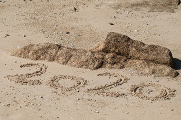 closeup of 2020 writing in the sand on the beach