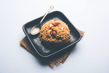 Traditional Jaggery Rice or Gur wale chawal in Hindi, served in a bowl with spoon. selective focus