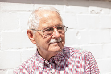 portrait of senior, old men smile and is relaxed in his garden with a white wand