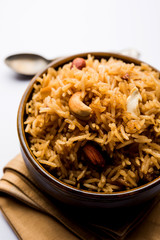Traditional Jaggery Rice or Gur wale chawal in Hindi, served in a bowl with spoon. selective focus