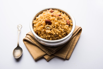 Traditional Jaggery Rice or Gur wale chawal in Hindi, served in a bowl with spoon. selective focus