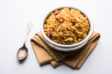 Traditional Jaggery Rice or Gur wale chawal in Hindi, served in a bowl with spoon. selective focus