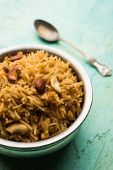Traditional Jaggery Rice or Gur wale chawal in Hindi, served in a bowl with spoon. selective focus