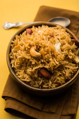 Traditional Jaggery Rice or Gur wale chawal in Hindi, served in a bowl with spoon. selective focus