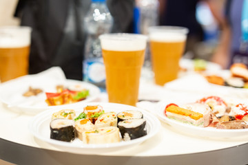 Beer and small buffet bites in plates on table food and drink concept.