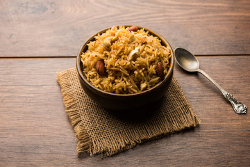Traditional Jaggery Rice or Gur wale chawal in Hindi, served in a bowl with spoon. selective focus