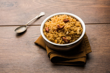 Traditional Jaggery Rice or Gur wale chawal in Hindi, served in a bowl with spoon. selective focus