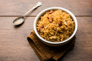 Traditional Jaggery Rice or Gur wale chawal in Hindi, served in a bowl with spoon. selective focus