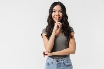 Young woman posing isolated over white wall background showing silence gesture.