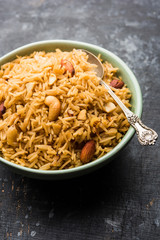 Traditional Jaggery Rice or Gur wale chawal in Hindi, served in a bowl with spoon. selective focus