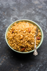 Traditional Jaggery Rice or Gur wale chawal in Hindi, served in a bowl with spoon. selective focus