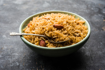 Traditional Jaggery Rice or Gur wale chawal in Hindi, served in a bowl with spoon. selective focus