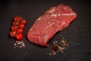 top view large sirloin of raw marbled meat with tomatoes