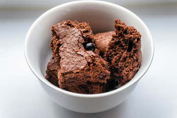 chocolate brownies with fresh berries and chocolate background, side view