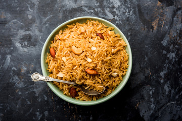 Traditional Jaggery Rice or Gur wale chawal in Hindi, served in a bowl with spoon. selective focus