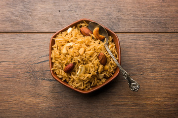 Traditional Jaggery Rice or Gur wale chawal in Hindi, served in a bowl with spoon. selective focus