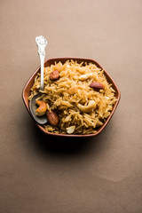Traditional Jaggery Rice or Gur wale chawal in Hindi, served in a bowl with spoon. selective focus