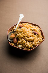 Traditional Jaggery Rice or Gur wale chawal in Hindi, served in a bowl with spoon. selective focus