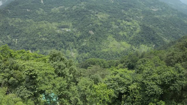 Aerial, rising, drone shot, above Indian mountain jungle, on a partly sunny day, in Sikkim, India