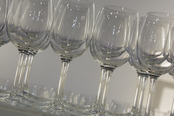 Welcome drink. Rows of empty wine or champagne glasses close up. glass goblets on the white table. Empty crystal wineglass. glass goblet on a high leg. Restaraunt bar concept.