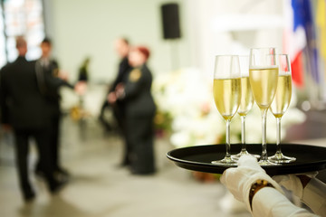 A tray with three glasses of champagne. Waiter holding a tray with a champagne glass