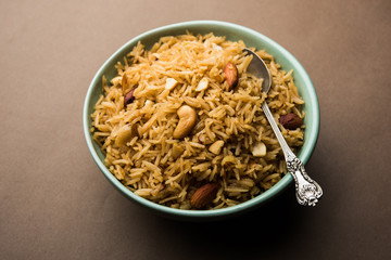 Traditional Jaggery Rice or Gur wale chawal in Hindi, served in a bowl with spoon. selective focus