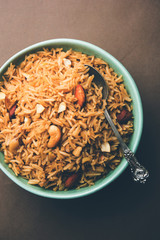 Traditional Jaggery Rice or Gur wale chawal in Hindi, served in a bowl with spoon. selective focus