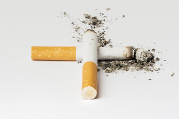 Two half burned cigarettes forming a cross